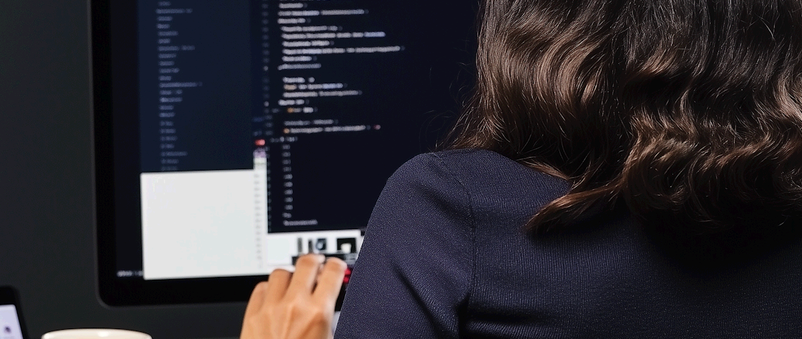 Person from behind coding on a computer screen | It Outsourcing | Parallel Outsourcing