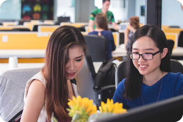 Two young women collaborating at a desk in an office | It Outsourcing | Parallel Outsourcing