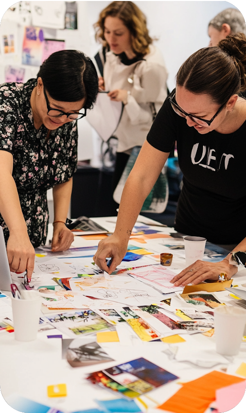 People gathered around a table, drawing and arranging images| It Outsourcing | Parallel Outsourcing