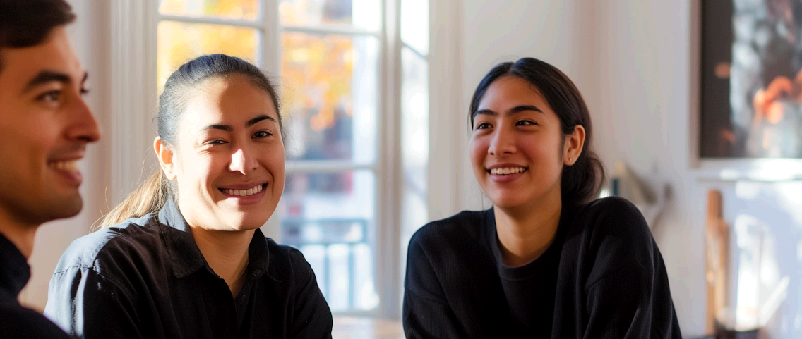 Three young adults smiling and talking indoors | Offshore Web Development | Parallel Outsourcing