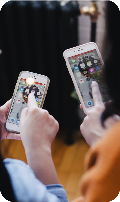 Hands on two smartphones, interacting with apps | Offshore Outsourcing | Parallel Outsourcing