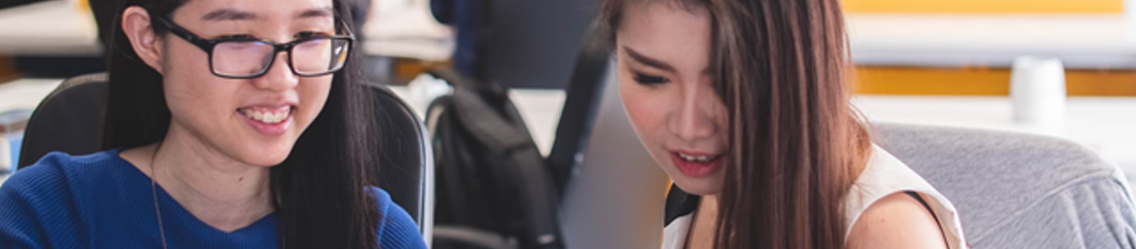 Two young women looking at something together | It Outsourcing | Parallel Outsourcing