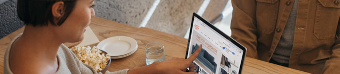 Woman pointing at laptop screen with a bowl of popcorn | Admin Outsourcing | Parallel Outsourcing